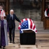 President Biden touches the casket after delivering remarks at the state funeral of former President Jimmy Carter at Washington National Cathedral on Thursday in Washington, D.C.