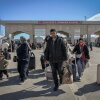 Iranians carrying their belongings arrive in Turkey after passing through a border crossing.