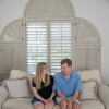 Cody and Kaleigh Brendle sit together on a beige sofa at their home.