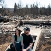 Melissa and Christopher Matthews in front of the remains of their home in Spokane on August 14, 2026. The Spokane Complex fires have caused over 900 structures to burn down.
