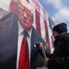 A man writes a slogan on a portrait of the U.S. President Donald Trump during a rally commemorating anniversary of Iran's 1979 Islamic Revolution that toppled the late pro-U.S. Shah Mohammad Reza Pahlavi and brought Islamic clerics to power, in Tehran, Iran, Monday, Feb. 10, 2025. Trump says the U.S. and Iran will have direct nuclear talks soon.