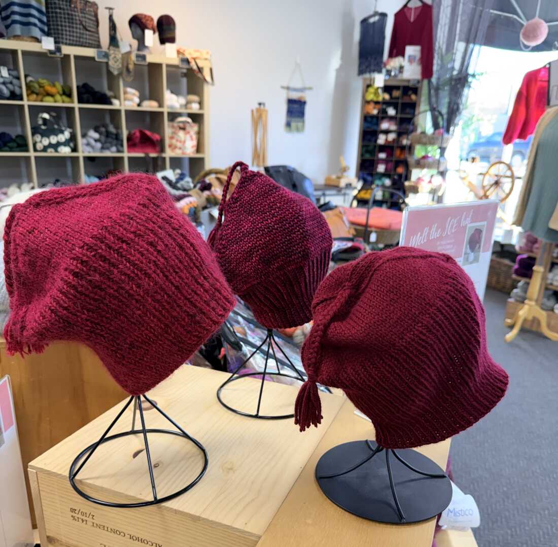 Handmade red "Melt the ICE" hats are on display at Minneapolis yarn store Needle & Skein.