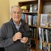 John Biever poses with a camera in front of some memorabilia at his San Diego home.