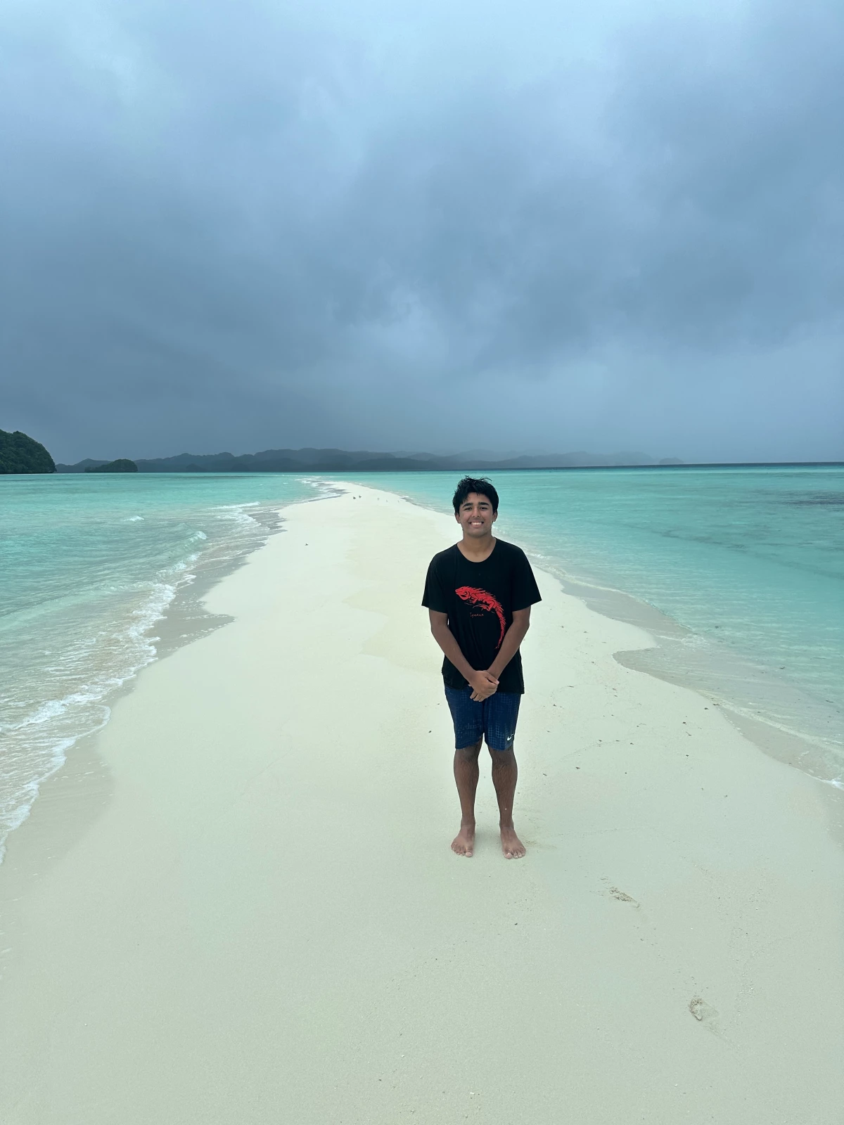 Arjun Malaviya stands on a sandbank in Papua New Guinea. He told NPR that he's the youngest solo traveler to visit 100 countries. 'I was 17 years and 228 days old when I reached my 100th country,' he said.