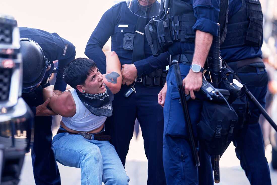 A protester is detained in downtown Los Angeles, Sunday, June 8, 2025, following last night's immigration raid protest.