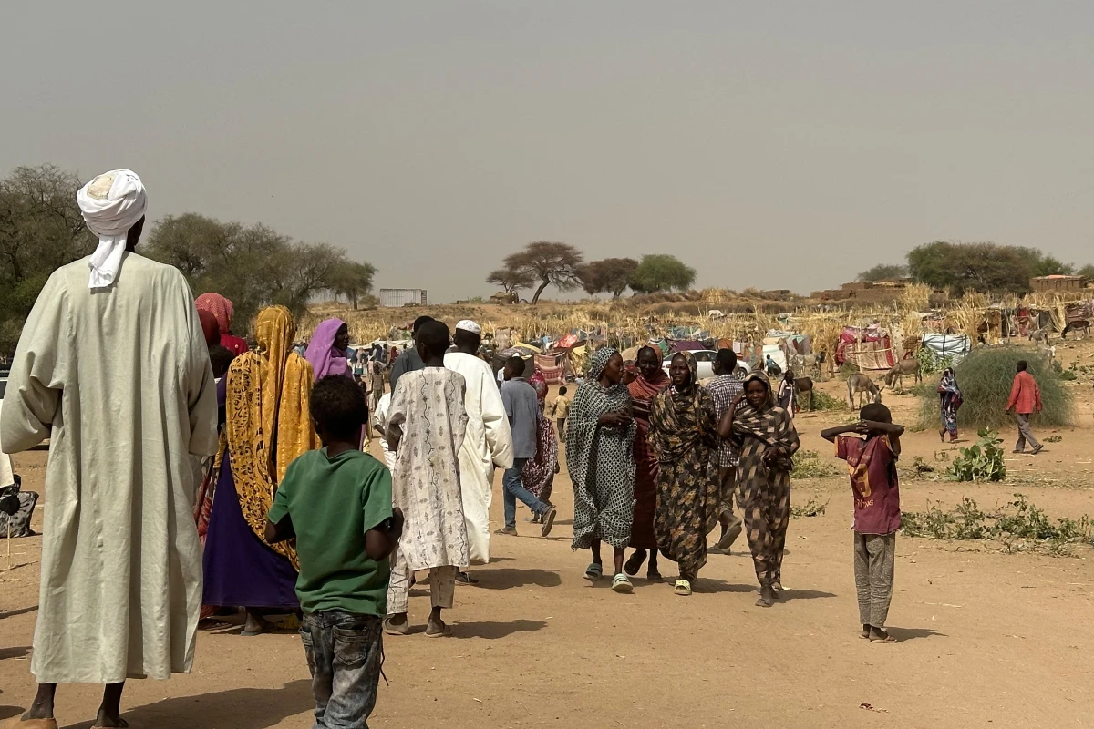 People who fled violence in Darfur walk through a makeshift encampment in the western Darfur region on April 13, 2025.