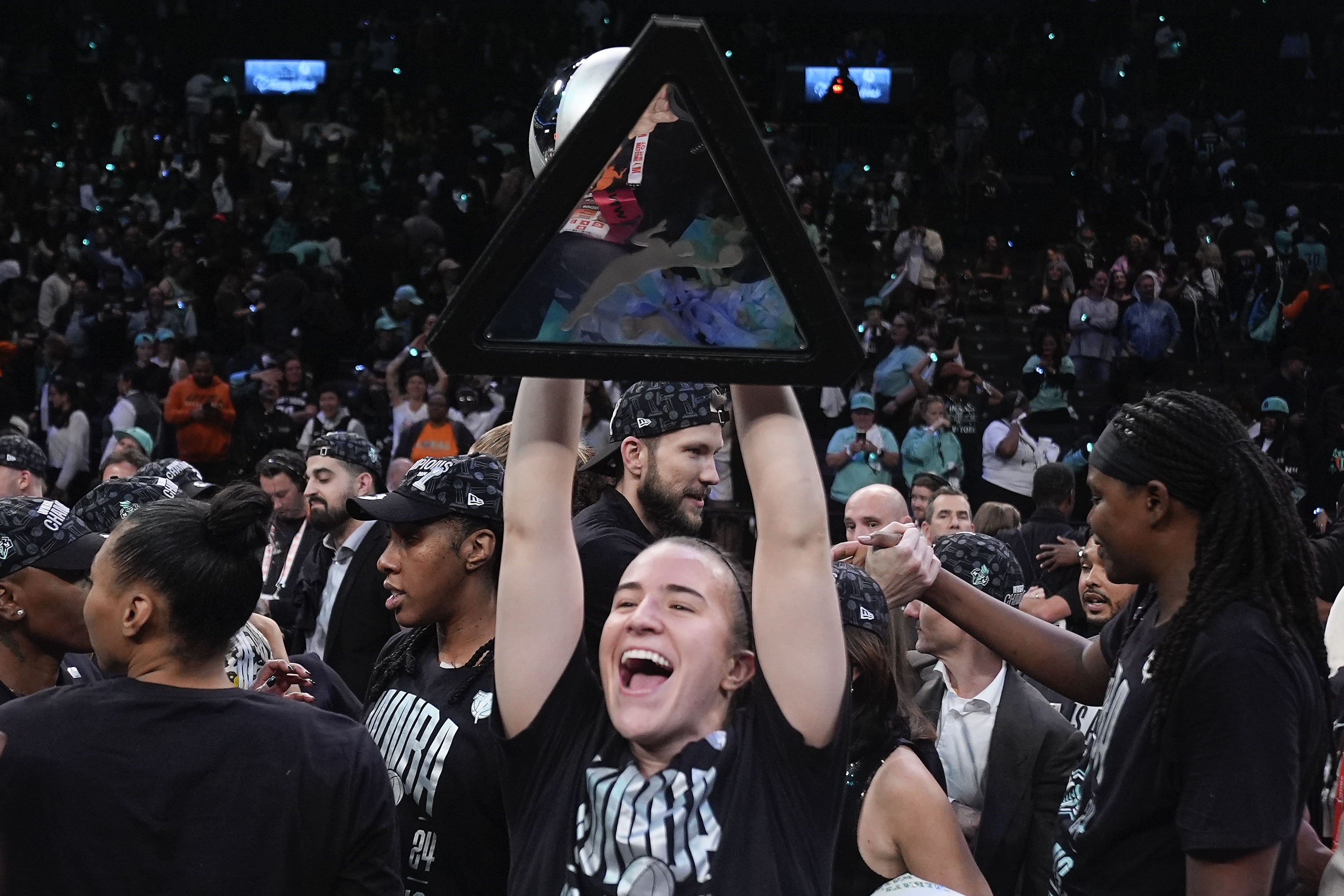 New York Liberty guard Sabrina Ionescu holds up the championship trophy after the Liberty defeated the Minnesota Lynx in Game 5 of the WNBA basketball final series, Sunday, Oct. 20, 2024, in New York. (AP)