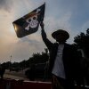 A number of human rights activists carry posters and wave the Straw Hat Pirates' Jolly Roger flag from the anime One Piece during the 873rd Kamisan Action in Jakarta, Indonesia, on August 14, 2025.