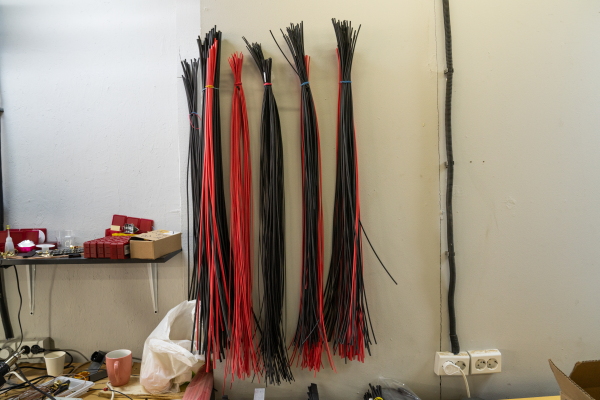 Plastic ties used in building drones hang from the wall over a workbench at Skyassist in Ukraine.