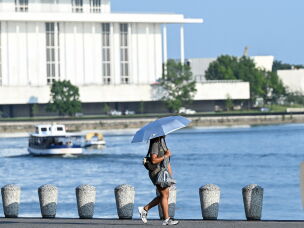 A person uses an umbrella to stay cool while walking along the Potomac River during a heatwave in Washington, DC, in July.