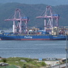 The container ship "Panstar Acro" is anchored to load containers at Busan New Port in Busan on August 22, 2026, as the vessel is scheduled to sail to Europe via the Arctic to test the commercial viability of the shipping route opened by melting ice. South Korea was set on August 22, to send its first trial container through the Arctic, as the Middle East war rattles global shipping, while environmental groups warned the route could accelerate polar ice melt.