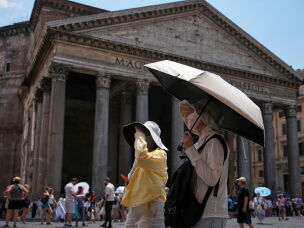 FILE - Tourists use umbrellas to take shelter from the sun in Pantheon Square in Rome, June 29, 2026.