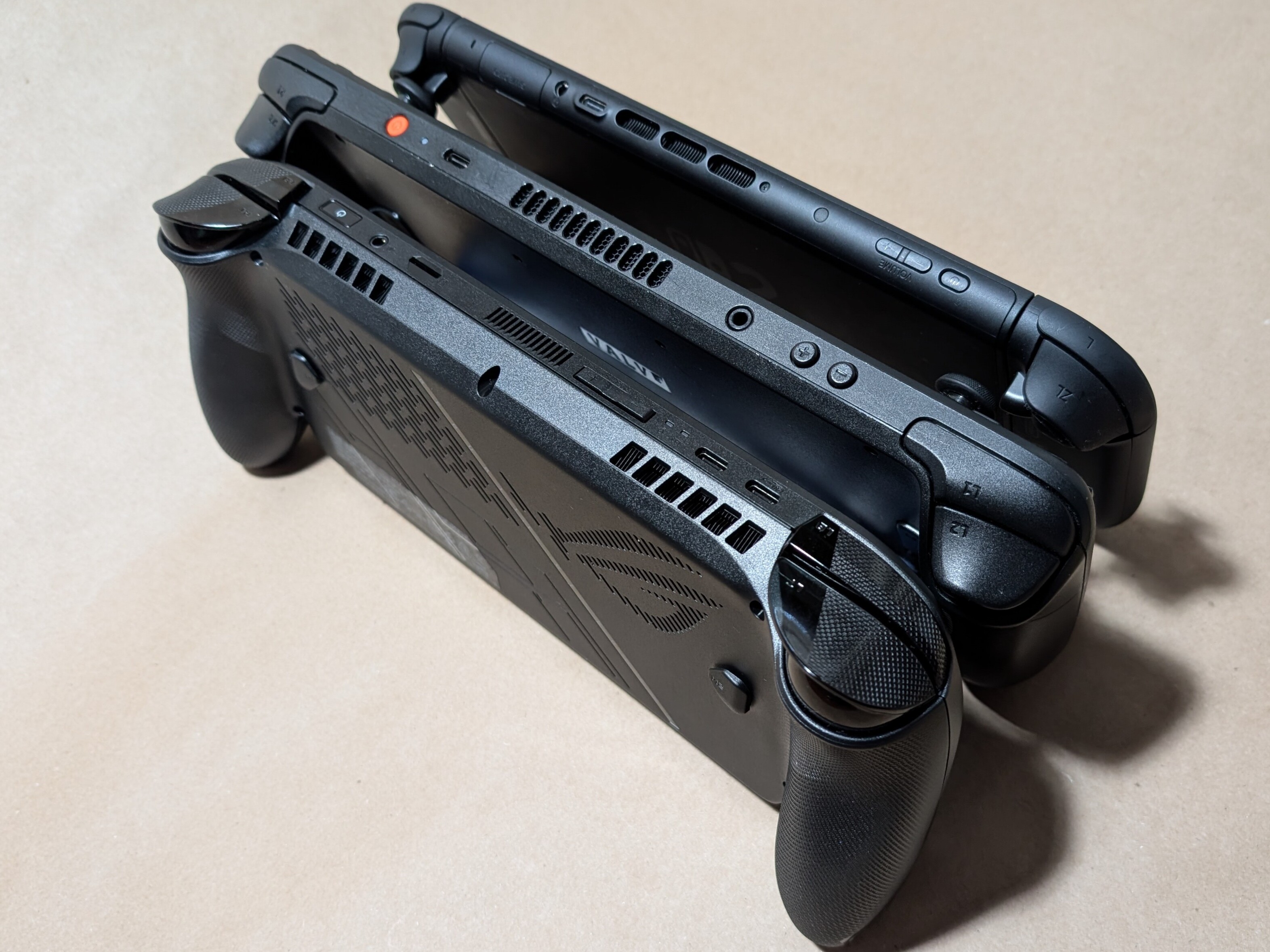 Une comparaison de l'épaisseur des appareils de jeu portables, de la Xbox Ally X (en bas), du OLED Steam Deck (au milieu) et de la Nintendo Switch 2 (en haut).