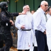 Rabbi Daniel Walker (third from left) stands among armed police officers as they talk with members of the Jewish community outside Heaton Park Hebrew Congregation synagogue in Crumpsall, north Manchester, following an attack at the synagogue on Thursday.