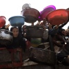 Palestinians, including children, hold out bowls and pans to receive hot meals distributed by charity organizations.