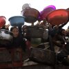 Palestinians, including children, hold out bowls and pans to receive hot meals distributed by charity organizations.