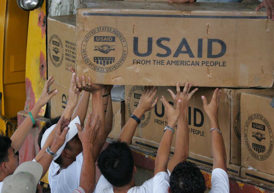 Volunteers of the Red Cross on the Philippines unload boxes of relief goods from the US Agency for International Development. The government has sued a number of USAID recipients because of President Trump's recent command to stop foreign aid.