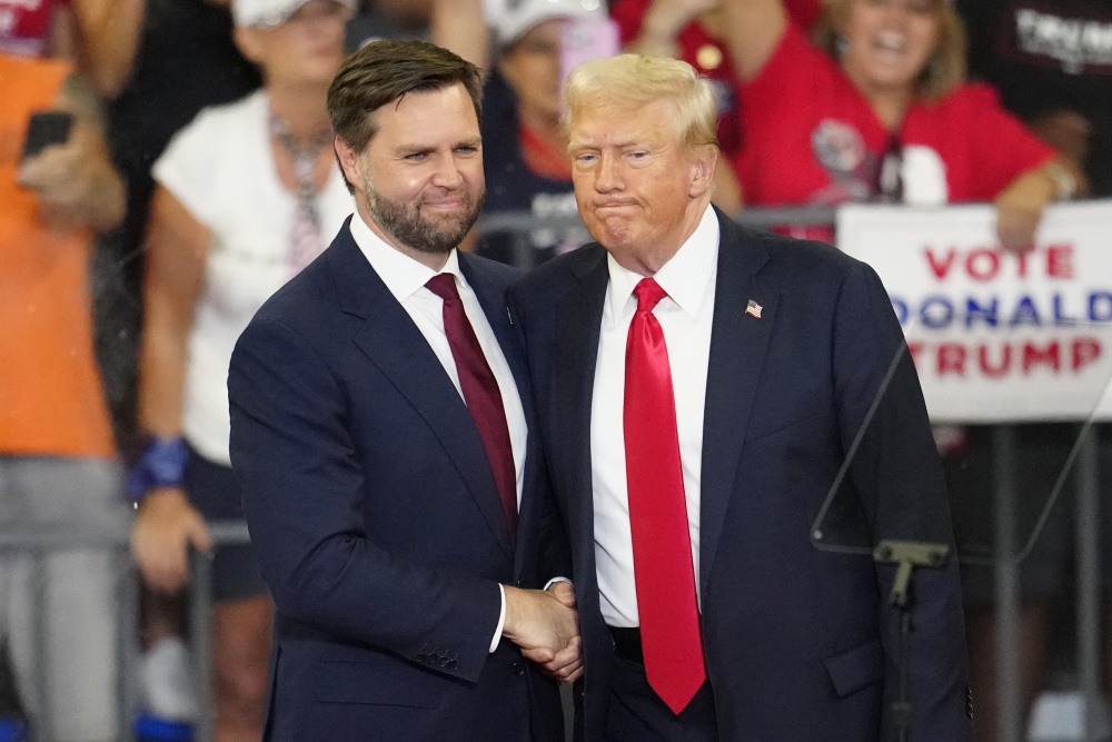 Former President Trump and his running mate, Sen. JD Vance of Ohio, shake hands at a campaign rally at Georgia State University in Atlanta, on Aug. 3, 2024.  (AP)