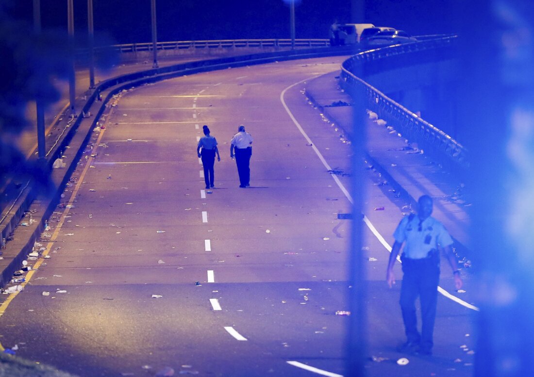 New Orleans police walk up the Almonaster Avenue bridge after a deadly shooting in New Orleans, Sunday, Nov. 17, 2024.