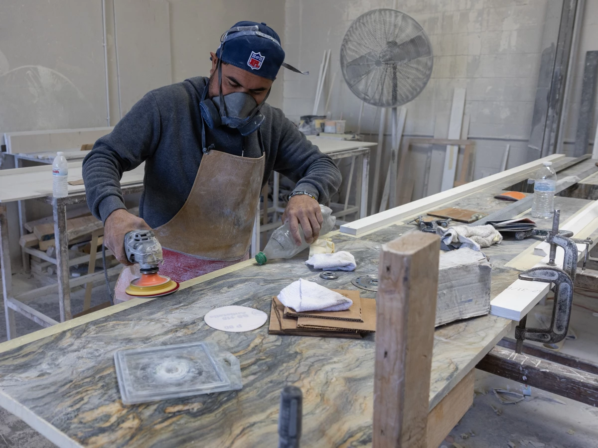 A stone countertop fabricator wears a mask to help protect against airborne particles which can contribute to silicosis at a shop in Sun Valley, Calif.