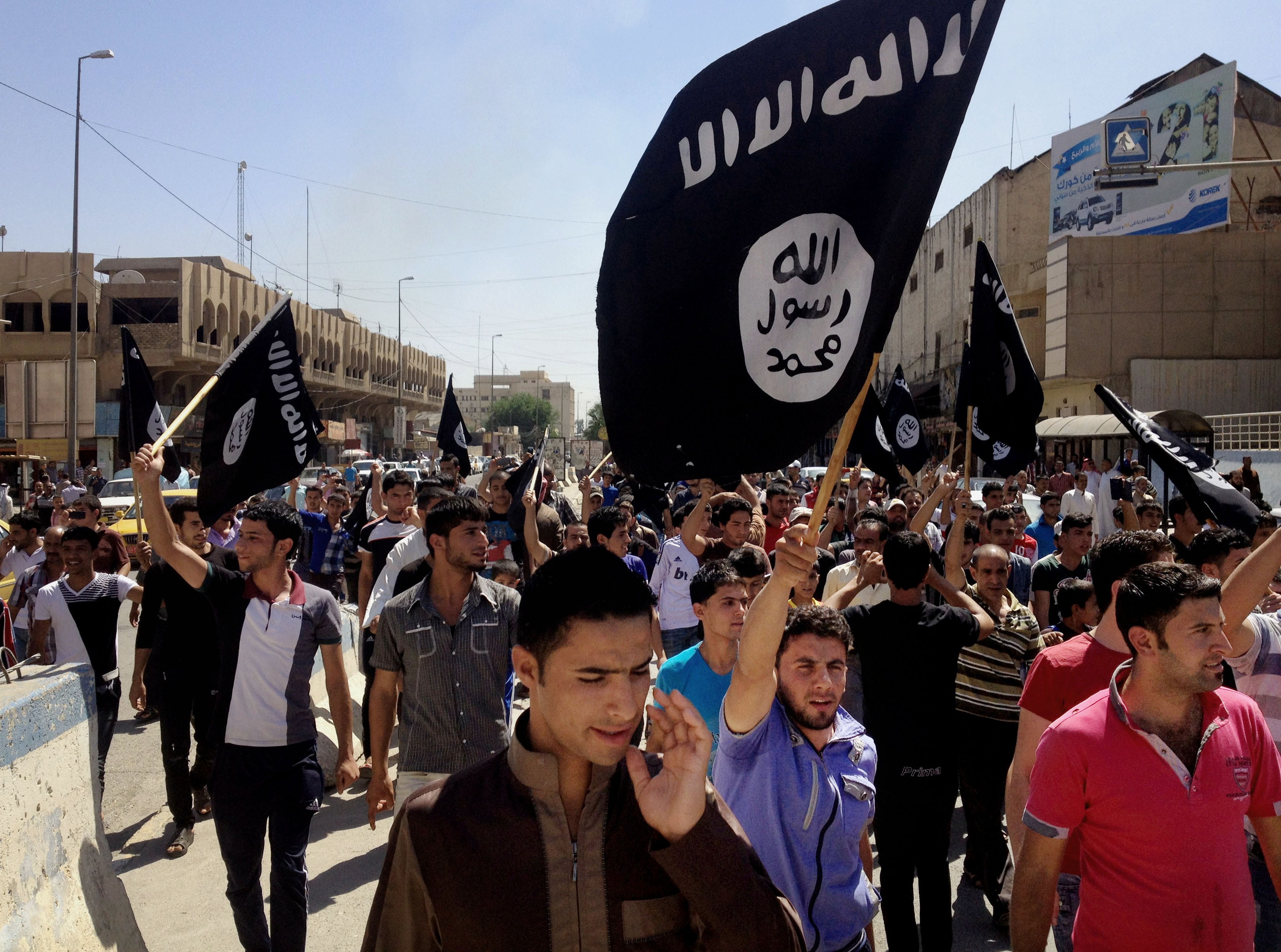 Demonstrators chant pro-Islamic State group slogans as they carry the group