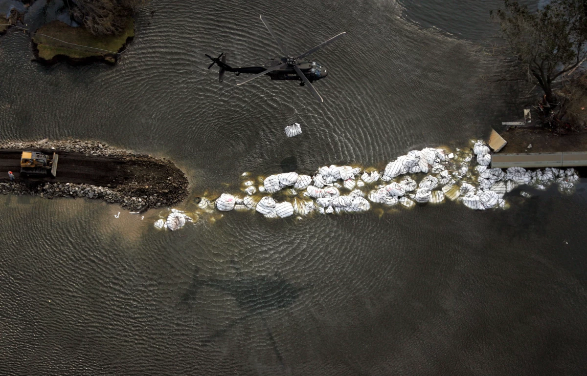A military helicopter drops a sandbag as work continues to repair the 17th Street canal levee in New Orleans, in the aftermath of Hurricane Katrina, on Sept. 5, 2005. After Hurricane Katrina's monster storm surge roared ashore, Corps-constructed levees and floodwalls failed near Lake Pontchartrain and along the Lower 9th Ward, inundating most of the city.