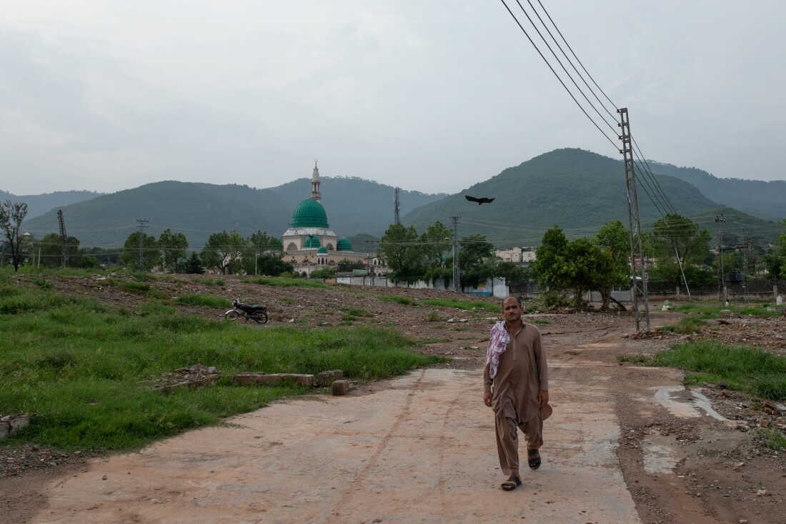 A man walks through an area where houses were demolished near Bari Imam on August 19, 2026 in Islamabad, Pakistan.