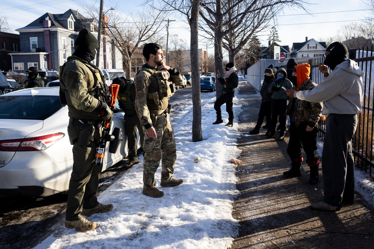 Observers and protesters confront U.S. Customs and Border Protection agents as they check the immigration status of two men in a car in South Minneapolis on Monday, Jan. 12, 2026.