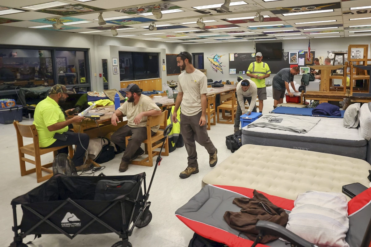 Members of Pasco County utilities set up in classrooms in a hurricane shelter at River Ridge Middle/High School in preparation for Hurricane Milton in New Port Richey, Fla., on Wednesday.