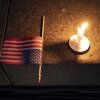 A U.S. flag and a candle sit on a step during a candlelight vigil and prayer event for Turning Point USA Founder Charlie Kirk on Sept. 10 in Seattle. Kirk was shot dead while speaking at Utah Valley University earlier in the day.