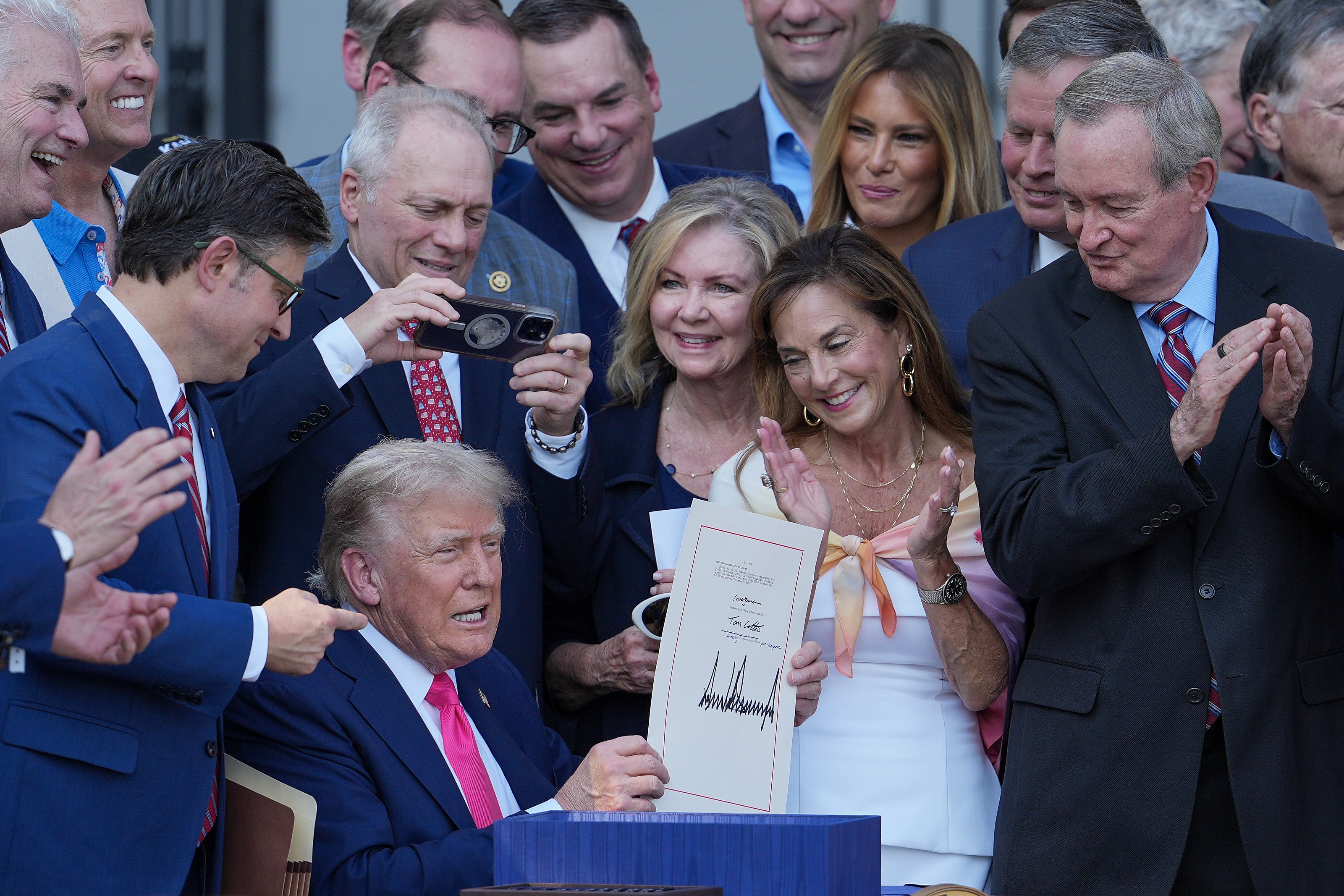 President Trump, joined by Republican lawmakers, signs the One, Big Beautiful Bill Act into law during an Independence Day military family picnic on the South Lawn of the White House on July 04 in Washington, D.C.