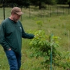 Thursday, May 21, 2026 — Former Forest Service researcher, Morgan Grove, examines Oak tree leaves at the Native Oak Tree Regeneration: Oak Orchard Site at Cylburn Arboretum in Baltimore, MD.
