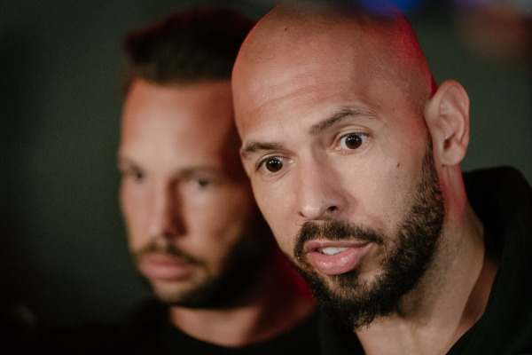 Andrew Tate and his brother Tristan Tate talk to the media outside their residence on March 23, 2025 in Bucharest, Romania.