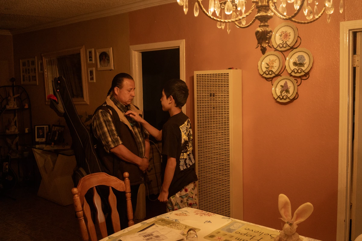 Paulo 'El Maniacs' Paredones, Spaghetti Cumbia's bass player, is blessed by his son, Tekuanotl Huitzitzilin, before he leaves for a show in the city's Boyle Heights neighborhood on March 30, 2023.