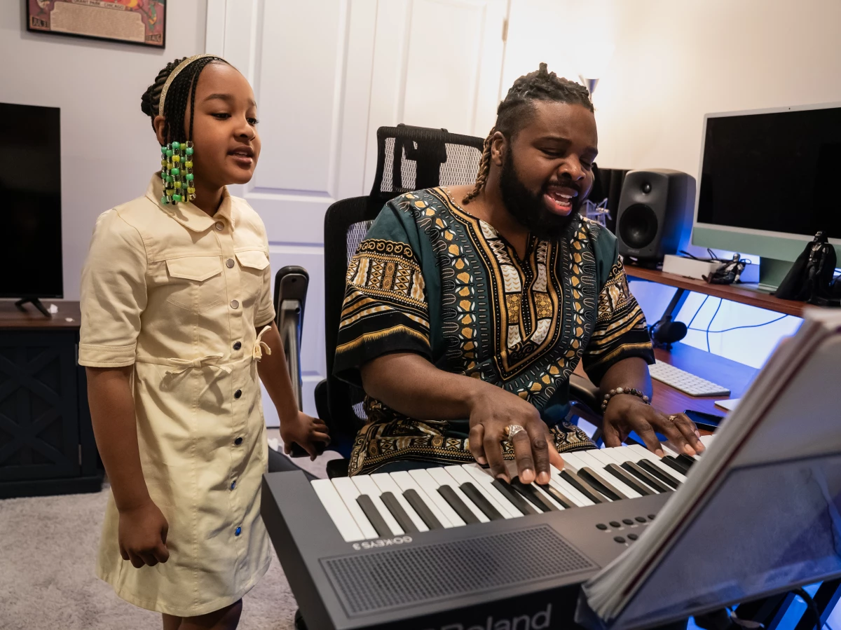 Grammy winners Aura Valentina Simmons, 8, and her father, Harold Simmons II, sing during a morning practice session in their home recording space before she goes to school in Charles County, Maryland. They go by the stage names Aura V and Fyütch.