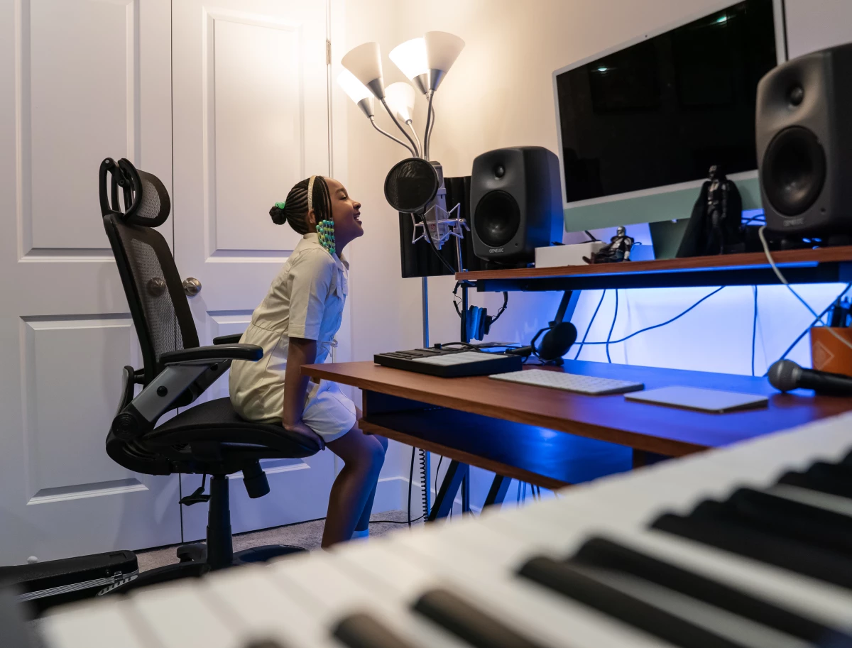 Aura sings into the microphone in her family's home studio.