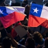 A supporter of Chile's presidential candidate Jose Antonio Kast, of the Republican Party, waves Chilean flags during his closing campaign rally in Santiago on Nov. 11, 2025.