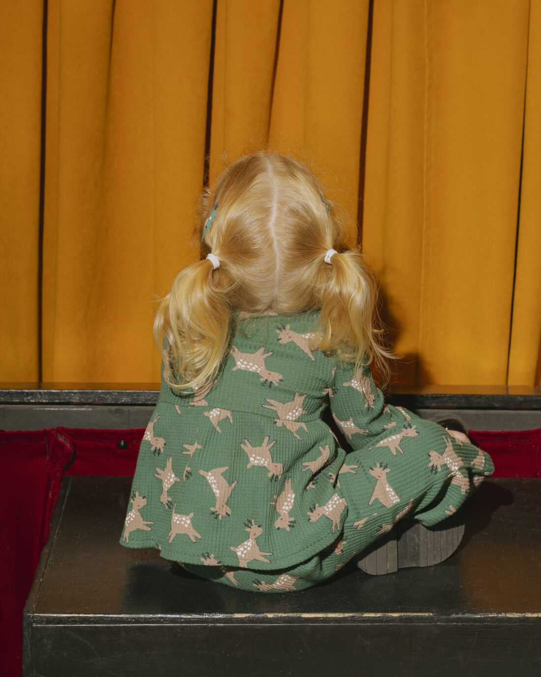 A child attending a 12:30PM showing at Puppetworks on December 6, dressed up in holiday attire.