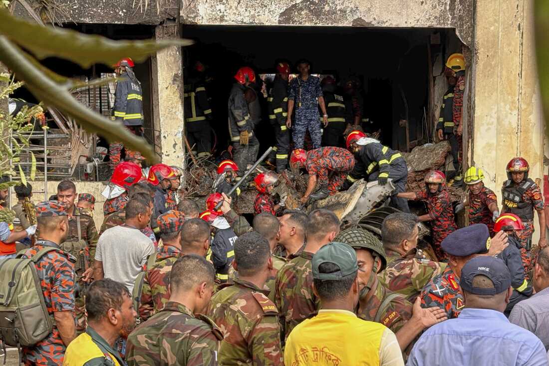 Firefighters check the wreckage of a Bangladesh Air Force training aircraft that crashed onto a school campus in Dhaka, Bangladesh, Monday.