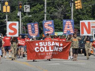 At the annual Moxie Day Parade in Lisbon, Maine, supporters of Sen. Susan Collins, R-Maine, march with signs and giant letters spelling S-U-S-A-N, on July 11.
