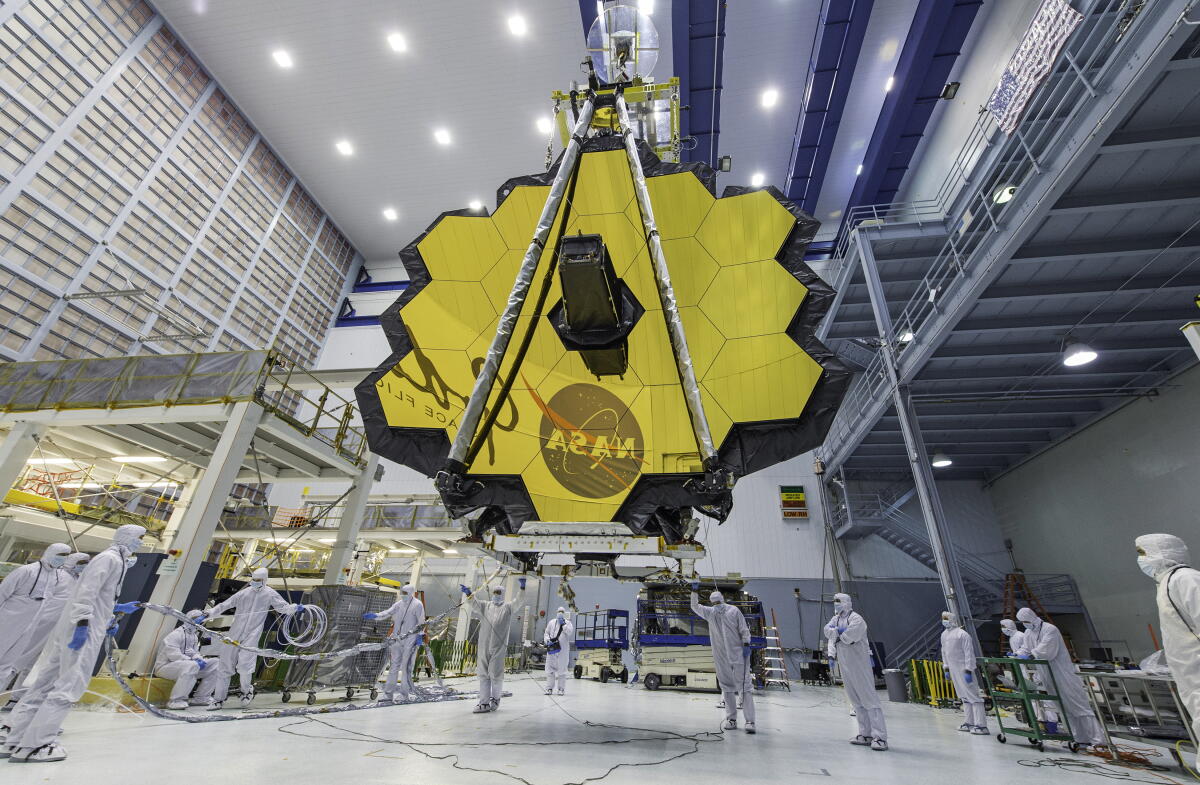 NASA rushed engineers out of their labs. They say it risks future space missions 4 Technicians lift a mirror of the James Webb Space Telescope using a crane at Goddard in 2017.