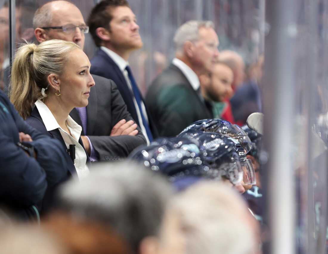 Jessica Campbell (left) was the assistant coach for the Coachella Valley Firebirds, working alongside Seattle Kraken coaches behind the bench during the second period of an NHL preseason hockey game against the Calgary Flames on Sept. 25 in Seattle.
