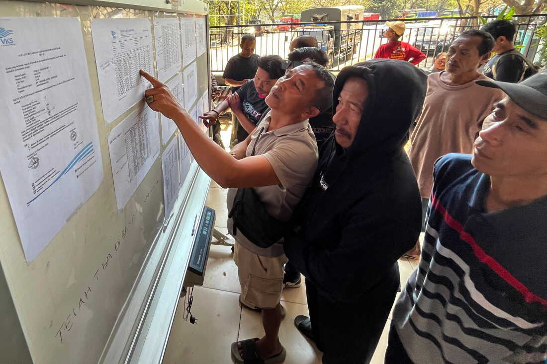 People check the passenger manifest of Virgo Transport 8 passenger ferry which overturned in bad weather in the Java Sea, at the rescuers' command center in Banjarmasin, South Kalimantan, Indonesia, Monday, Sept. 14, 2026.