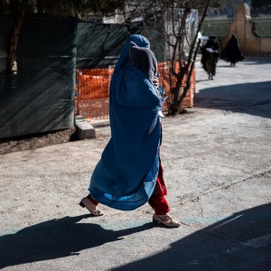 This photograph taken on January 8, 2026 shows an Afghan burqa-clad woman walking with her child at the Medecins Sans Frontieres (MSF) centre inside a hospital in Herat. In the country of more than 40 million people, there are relatively few medical centres that can help treat malnutrition. Some families travel hundreds of kilometres (miles) to reach Herat hospital as they lack healthcare facilities in their home provinces.