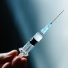 Illustration photo of a vaccine syringe in hand.