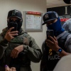 Two ICE agents film the press using smartphones in the hallway outside the immigration court at 26 Federal Plaza in New York USA on July 11 2025. The Department of Homeland Security has been acquiring new tools to identify people and monitor them.