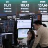 Currency traders watch monitors near a screen showing international oil prices at the foreign exchange dealing room of the Hana Bank headquarters in Seoul, South Korea, on March 18.