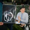 People hold images of victim Henry Nowak and blood-covered handcuffs as they take part in a protest outside of Southampton Central Police Station in Southampton, southern England, on Tuesday, following the murder of Nowak by Vickrum Digwa in December 2025.