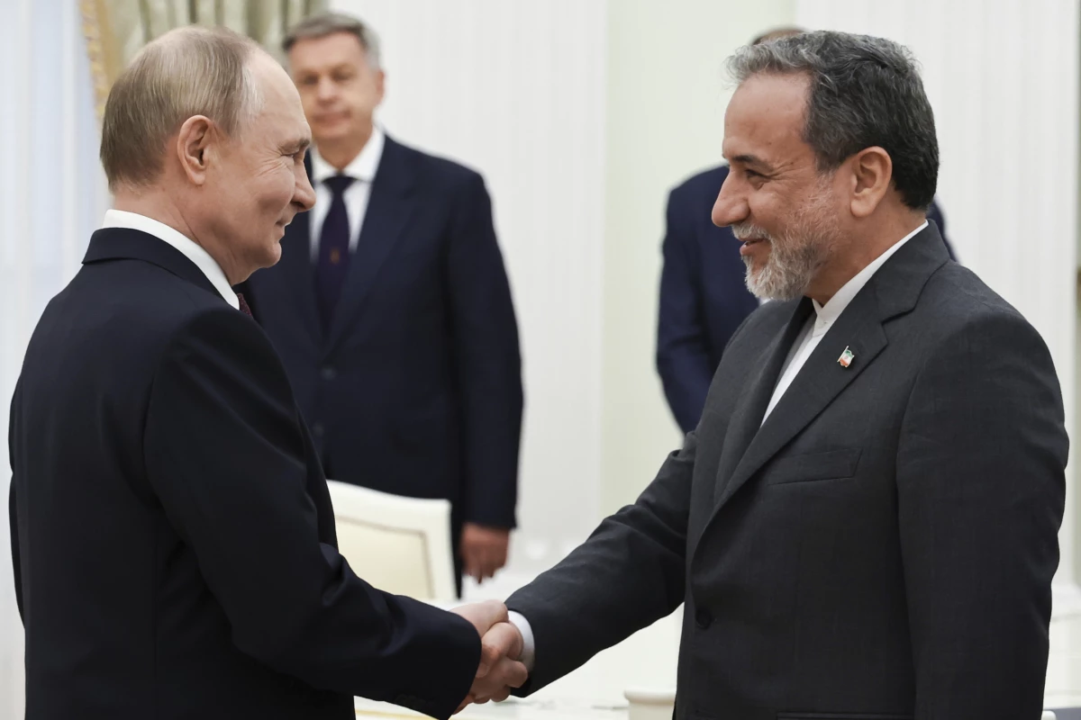 Russian President Vladimir Putin (left) greets Iranian Foreign Minister Abbas Araghchi prior to their talks at the Kremlin in Moscow, Monday.