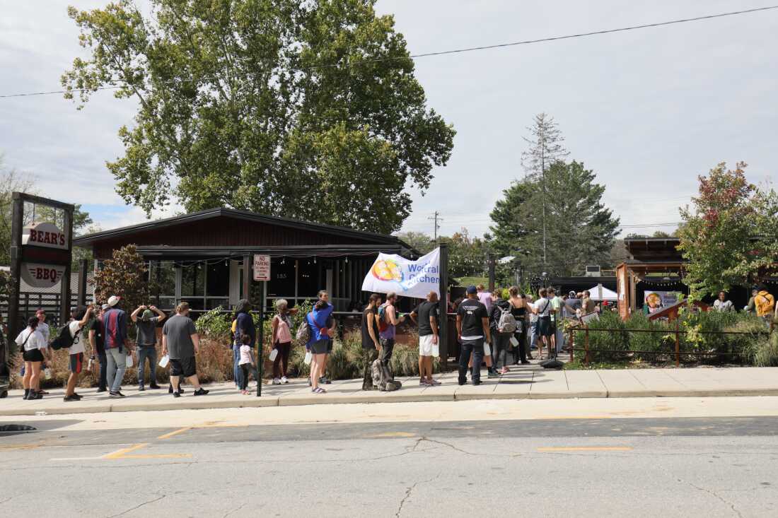 People in Asheville, N.C., line up for a meal outside Bear's Smokehouse BBQ on Monday.